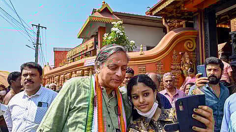Congress leader Shashi Tharoor poses for a selfie with a devotee during a visit at the Pazhavangani Ganapathy temple ahead of the Lok Sabha elections, in Thiruvananthapuram.