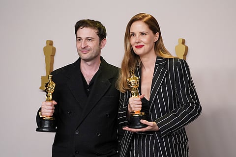 Arthur Harari, left, and Justine Triet pose with the award for best original screenplay for "Anatomy of a Fall" in the press room at the Oscars on Sunday, March 10, 2024, at the Dolby Theatre in Los Angeles.