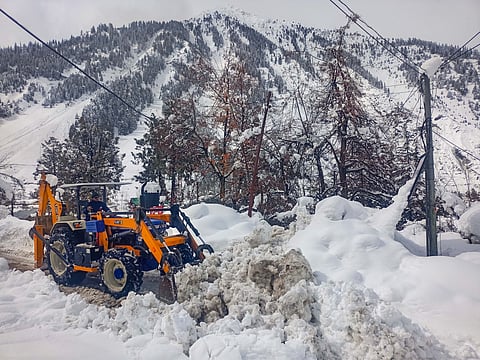 A snow clearing machine being used to remove snow from a road at Sissu, in Lahaul and Spiti district.