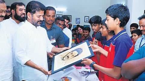 Chief Minister A Revanth Reddy looks at a portrait presented to him by a student after inaugurating the TMREIS school at Ibrahimbagh, Hyderabad on Friday