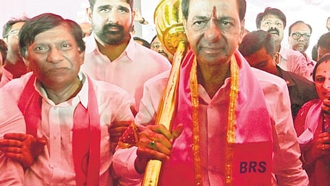BRS chief K Chandrasekhar Rao carries a mace presented to him during a public meeting in Karimnagar.
