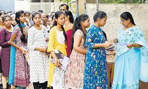 Teachers check hall tickets before students enter the examination hall in Karimnagar