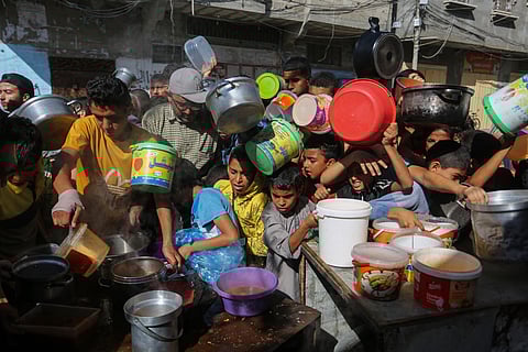 Palestinians crowd together as they wait for food distribution in Rafah, southern Gaza Strip.