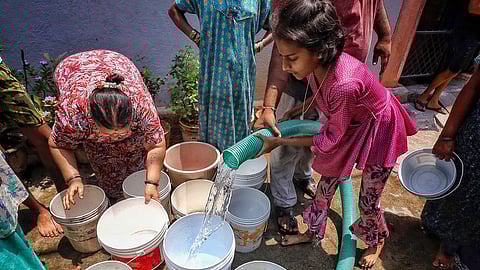 People collect drinking water from a water tanker amid the ongoing water crisis in Karnataka, in Bengaluru, Monday, March 18, 2024.