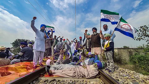 Farmers block railway tracks during their 'rail roko' protest, at Devi Das Pura, on the outskirts of Amritsar.