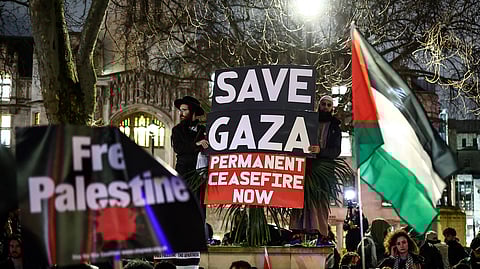 Pro-Palestinian demonstrators wave Palestinian flags and hold placards as they protest in Parliament Square in London on February 21, 2024, during an Opposition Day motion in the the House of Commons calling for an immediate ceasefire in Gaza.