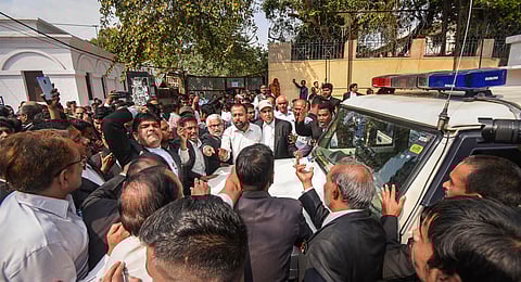 Lawyers stop a police vehicle after a transformer exploded and caught fire in a Civil Court premises, in Patna, Wednesday, March 13, 2024.
