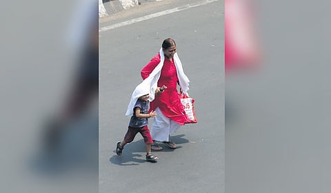 A woman seen protecting her child from summer heat in Vizag