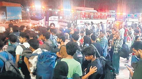 People wait at Kengeri Bus terminal in Bengaluru on Thursday to board buses to Kerala to caste their vote