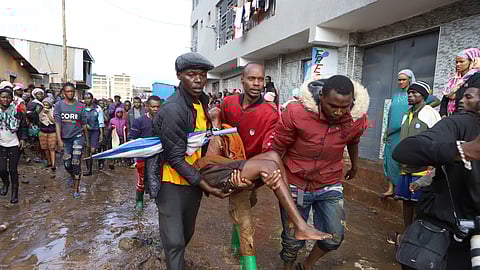 Residents rescue a woman who was caught during heavy rain in the Mathare slum of Nairobi, Kenya, Wednesday, Apr. 24, 2024.
