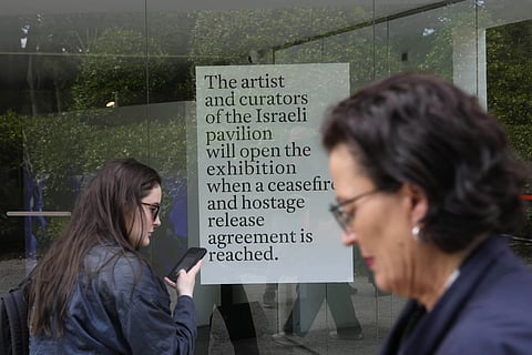 People stand in front of the closed Israeli national pavilion at the Biennale contemporary art fair in Venice, Italy, Tuesday, April 16, 2024.