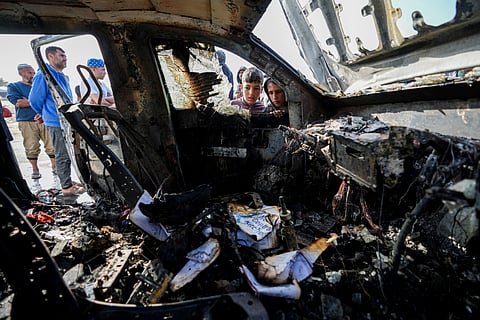 People inspect the site where World Central Kitchen workers were killed in Deir al-Balah, Gaza Strip, Tuesday, April 2, 2024.