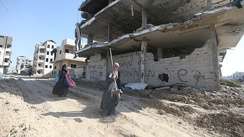 Palestinians walk through the destruction left by the Israeli air and ground offensive after they withdrew from Khan Younis, Gaza Strip.