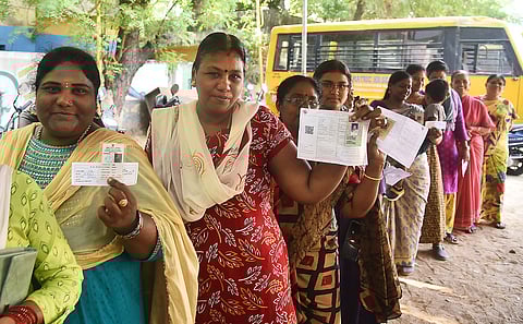 Women voters showing their voter id while casting their votes