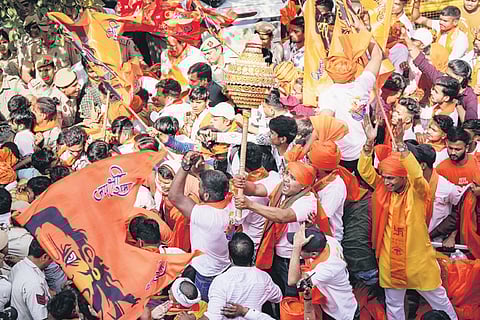 Security personnel attempt to control devotees during the procession