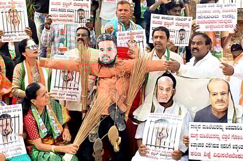 Congress leaders protest and burn photos of JD MP Prajwal Revann alleging his involvement in the sexual harassment case.