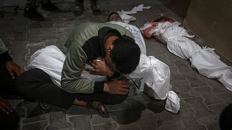 A Palestinian youth mourns his relative killed in the Israeli bombardment of the Gaza Strip, at the morgue of the Kuwaiti Hospital in Rafah refugee camp, southern Gaza Strip, early Saturday, April 20, 2024.