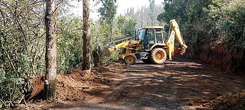 A earth mover vehicle is pressed into leveling the Pykara boat house road on Tuesday.
