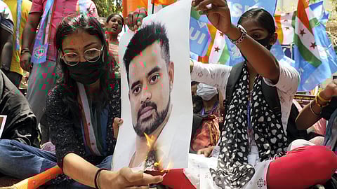 Protestors burn a poster of JD(S) MP Prajwal Revanna during a protest against his involvement in the alleged sexual abuse case.