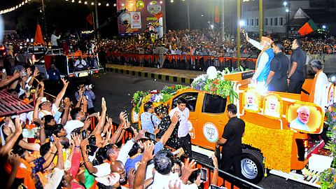 Prime Minister Narendra Modi waves at supporters before a road show ahead of Lok Sabha polls, in Mangaluru