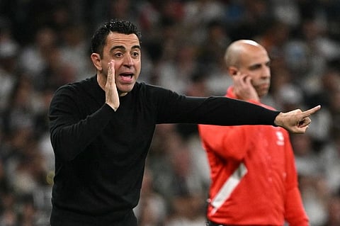Xavi gestures on the touchline during the La Liga match between Barcelona and Real Madrid at the Santiago Bernabeu stadium in Madrid
