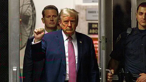 Former President Donald Trump gestures as he returns to the courtroom following a break in his trial.