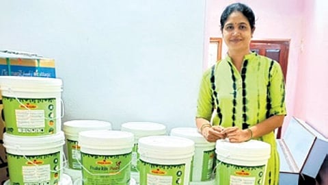 Akshata with cans of Sannidhi Prakritik paint made from cowdung