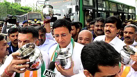 AICC General Secretary Randeep Singh Sujewal with other leaders and supporters protest against BJP central government holding a steel pot to show people that if they believe BJP they give nothing in Bengaluru on Saturday.