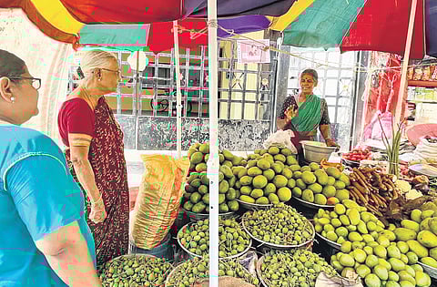 A vendor explains about mangoes to her customer