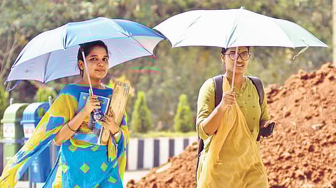 Holding umbrellas, two girls ventured out in Vijayawada.