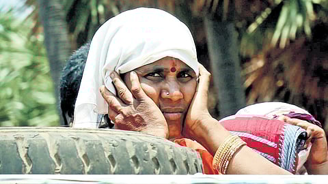 A woman seen protecting her head from heat.