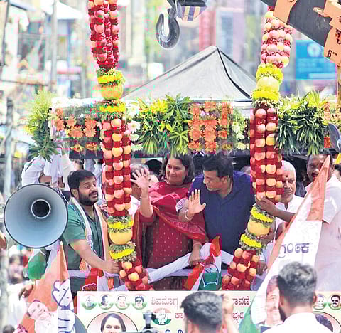 Shivamogga Congress candidate Geetha Shivarajkumar and her husband and actor Shiva Rajkumar wave at the crowd during a procession in Shivamogga on Monday