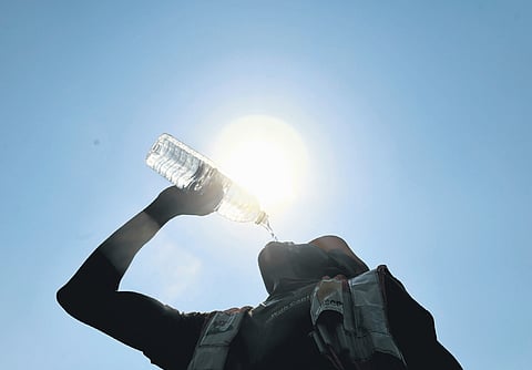 A construction worker quenches his thrust on a summer afternoon in Hyderabad