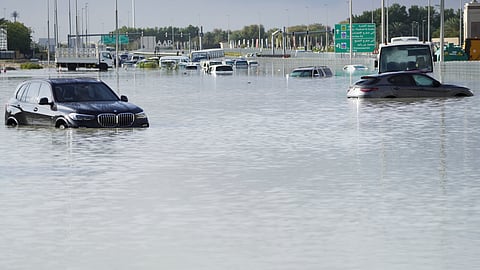 Vehicles sit abandoned in floodwater covering a major road in Dubai, United Arab Emirates.