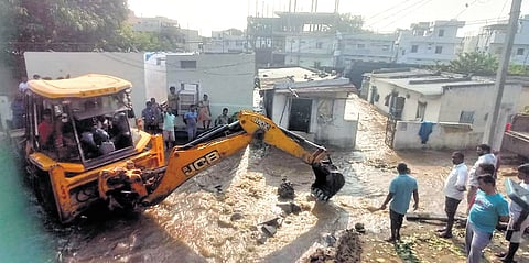 Officials use an excavator to contain the breach at Journalist Colony in Armoor