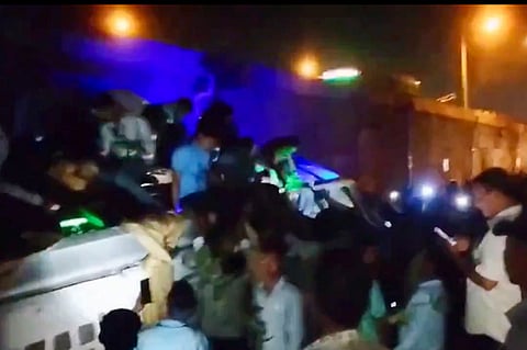 Passengers try to exit the bus after it fell down from a flyover, in Jajpur, Monday, April 15, 2024. Several people suffered injuries.