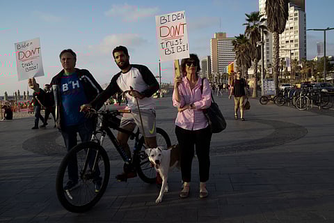 People hold up signs referring to the U.S. president Joe Biden to not trust in the Israeli Prime Minister Benjamin Netanyahu as they demonstrate demanding the end of the Israel-Hamas war with a regional peace agreement outside of the U.S. Embassy Branch Office in Tel Aviv, Monday, April 15, 2024.