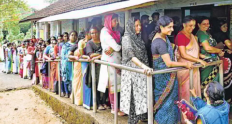Voters queue up in front of a polling booth.