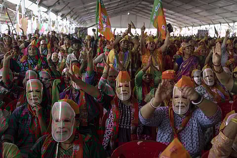 Bharatiya Janata Party (BJP) supporters wear masks of Indian Prime Minister Narendra Modi during an election rally.