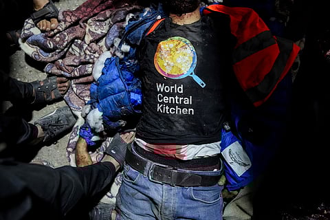 The body of a person wearing a World Central Kitchen t-shirt lies on the ground at the Al Aqsa hospital in Deir al-Balah, Gaza Strip, Monday, April 1, 2024. World Central Kitchen, an aid group, says an Israeli strike that hit its workers in Gaza killed at least seven people, including several foreigners.