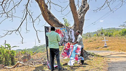 Anti-defacement squad members of the Election Commission remove illegal campaign posters at Bonacaud Estate junction in Thiruvananthapuram.