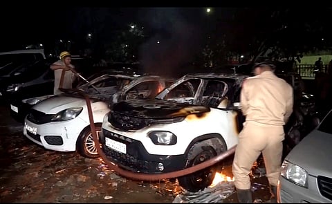 Firefighter souse flame in vehicles after a fire broke out at a civic authority-run parking lot in Madhu Vihar area of east Delhi, late Tuesday night, May 28, 2024.