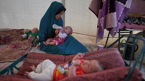 A Palestinian mother and her triplets shelter in their tent at a displacement camp in Deir el-Balah in the central Gaza Strip on April 30, 2024, amid the ongoing conflict between Israel and the militant Hamas group.