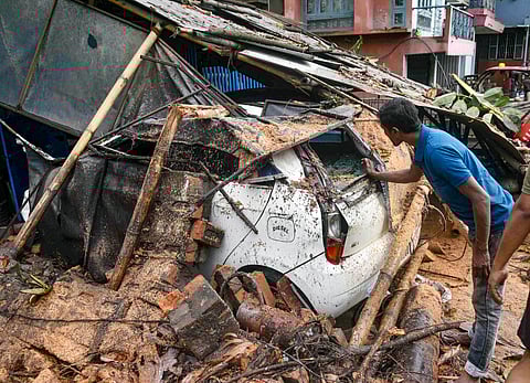 A car damaged afer a shed fell on it after the landfall of Cyclone Remal, in Guwahati.