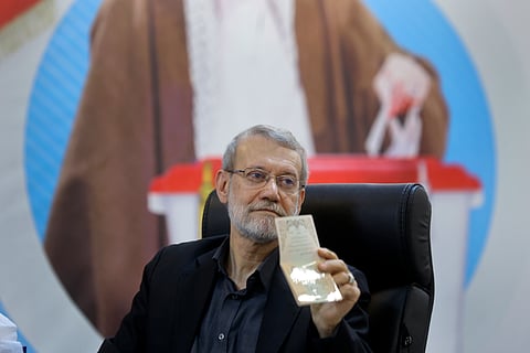 Former Iran's parliament speaker Ali Larijani shows his identification document to media while registering his name as a candidate for the June 28 presidential elections