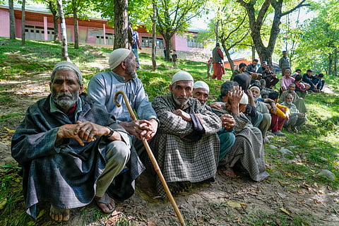 People wait in a queue to cast their votes at a polling booth during the sixth phase of Lok Sabha elections, at Noorbabad area in Kulgam district of South Kashmir