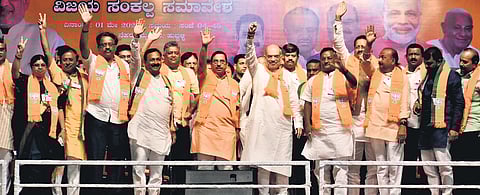 Union Ministers Amit Shah and Pralhad Joshi and other BJP leaders wave at the crowd at a rally in Hubballi on Wednesday.
