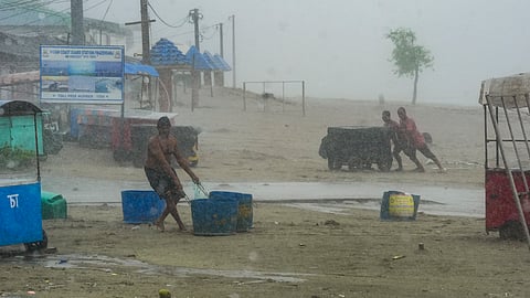 People move their belongings away from the seashore amid rain, ahead of the landfall of Cyclone 'Remal', in South 24 Parganas district, Sunday.
