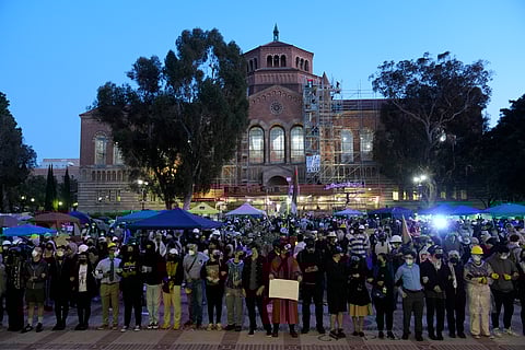 Pro-Palestinian demonstrators lock arms on the UCLA campus Wednesday, May 1, 2024, in Los Angeles.