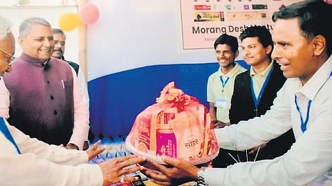 Amardeep Kumar gifts a basket of incense sticks to Bihar Chief Minister Nitish Kumar.